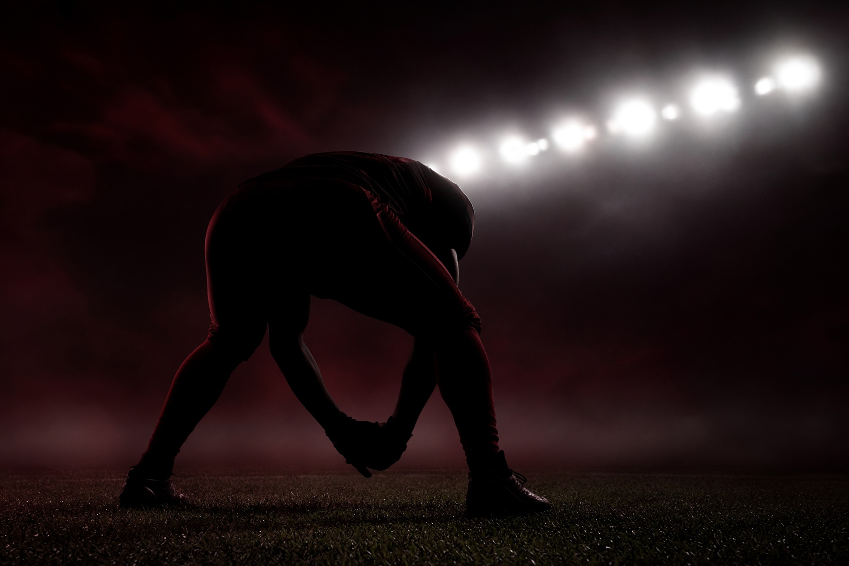 Long snapper silhouette under stadium lights